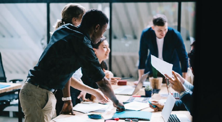 Group of young professionals collaborating on a project in an office.