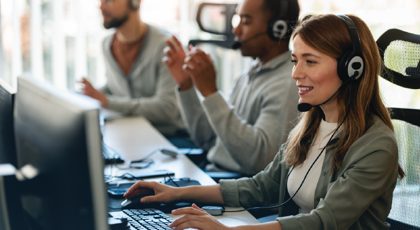 three customer support workers wearing headsets. 